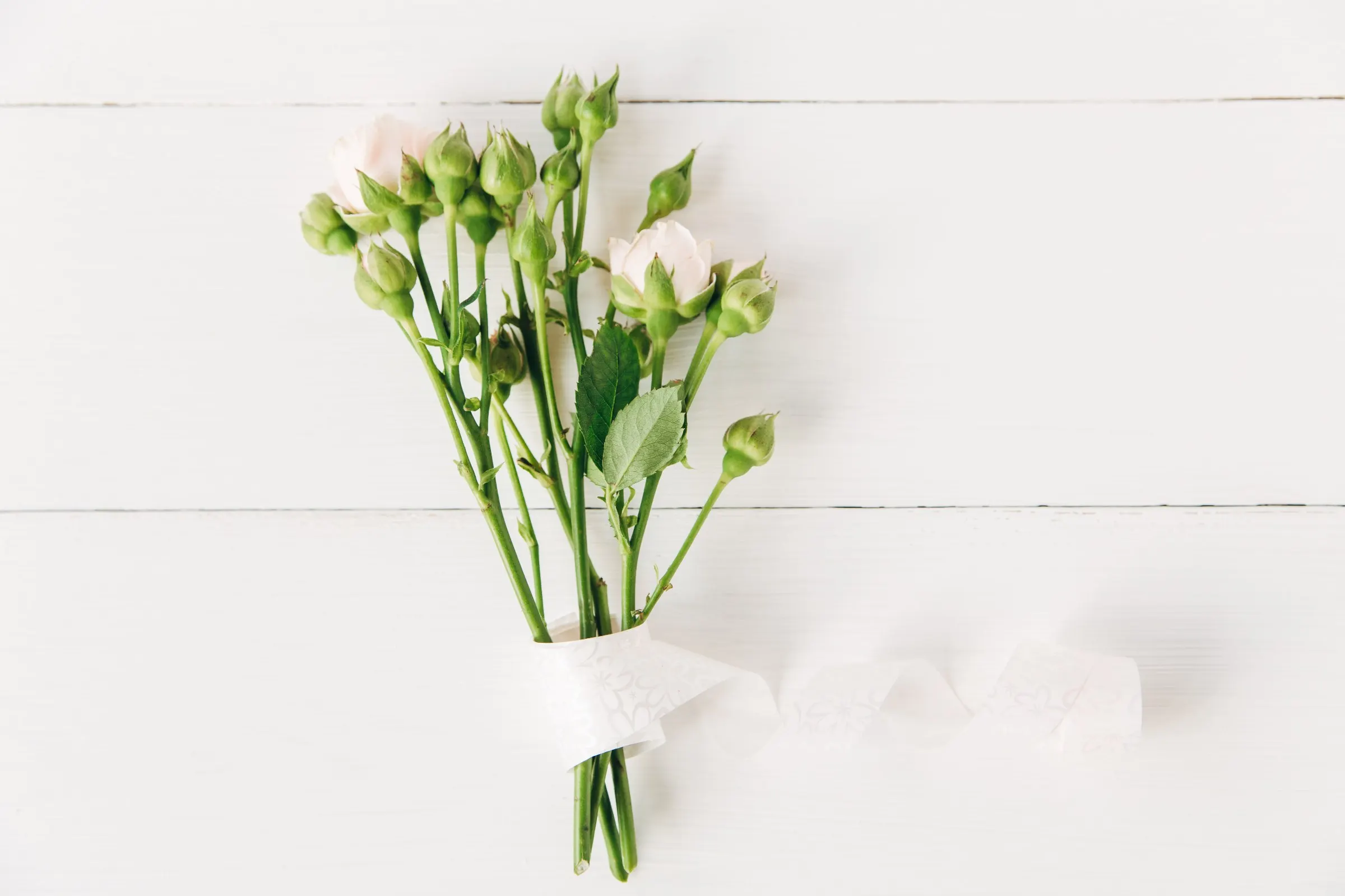 Petit bouquet de renoncules blanches, de lisianthus et de feuillage vert tendre
