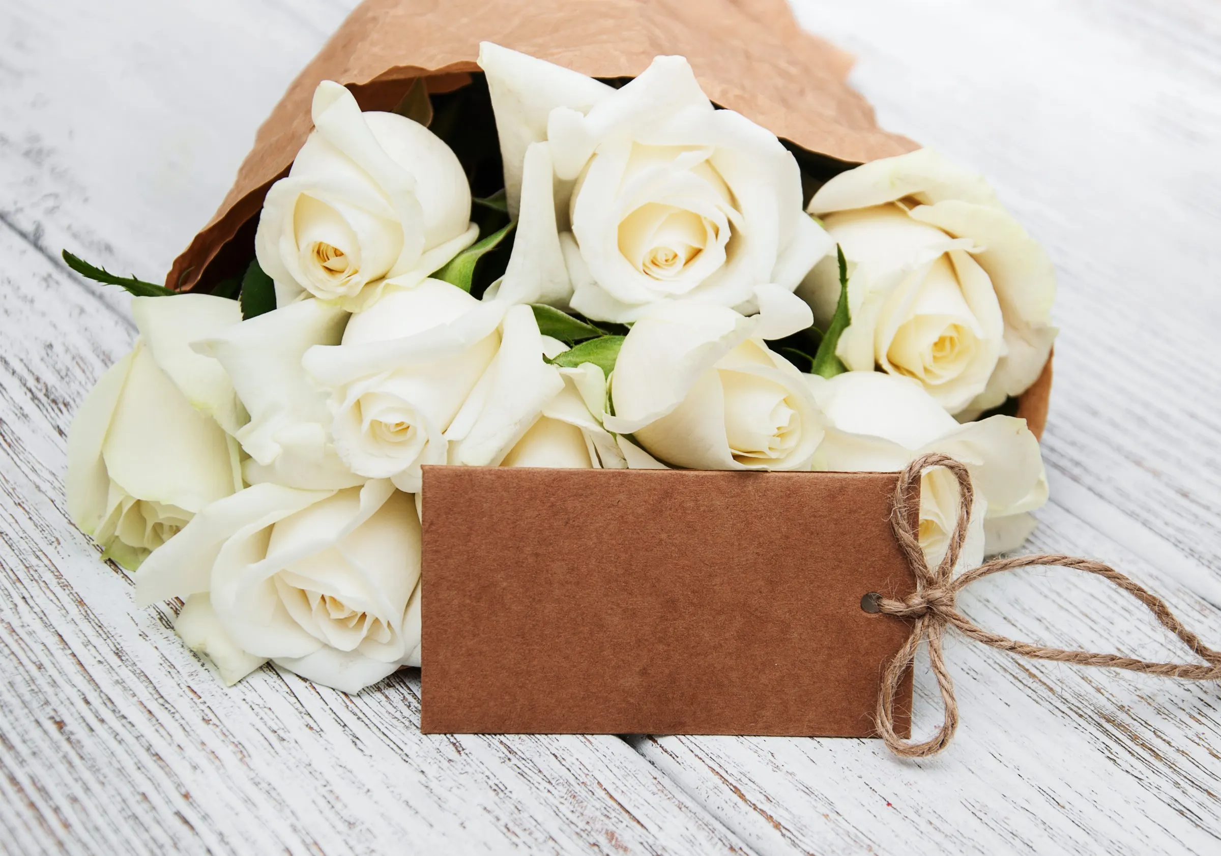 Petit bouquet de roses blanches accompagné d'une carte